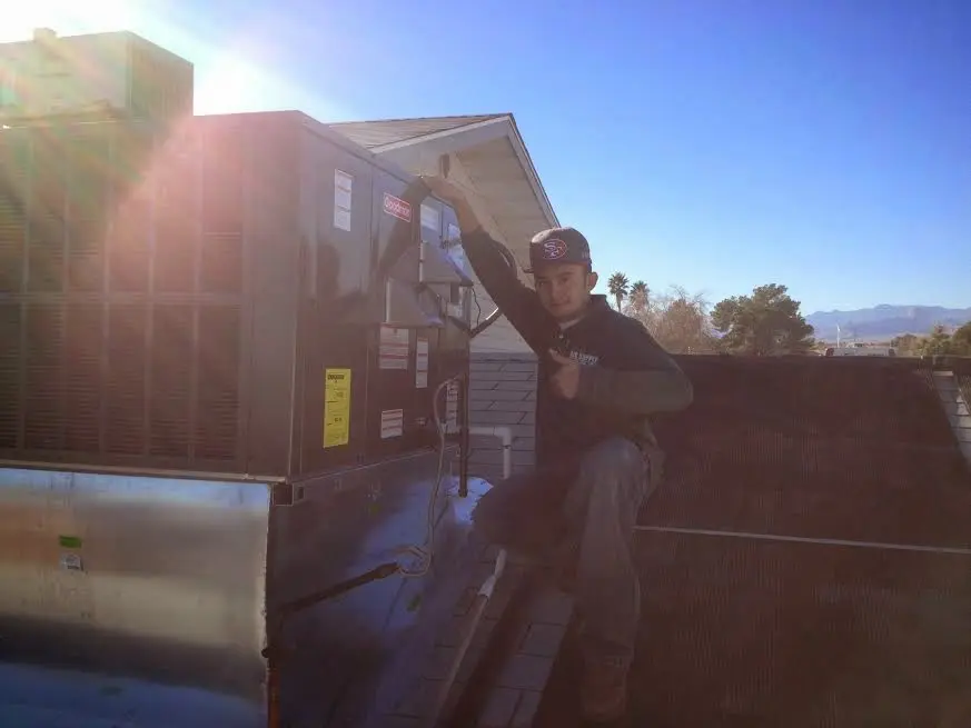 HVAC technician performing AC Tune-Up on a rooftop unit in Northbrook